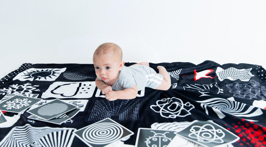 Baby Floor Blanket for Tummy Time, little guy looking at high contrast flashcards and laying on baby floor mat.