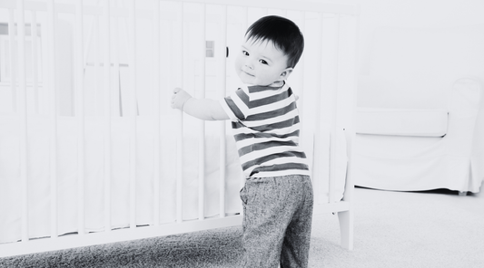 Little guy standing and smiling as he grows and learns while engaging in high contrast baby products