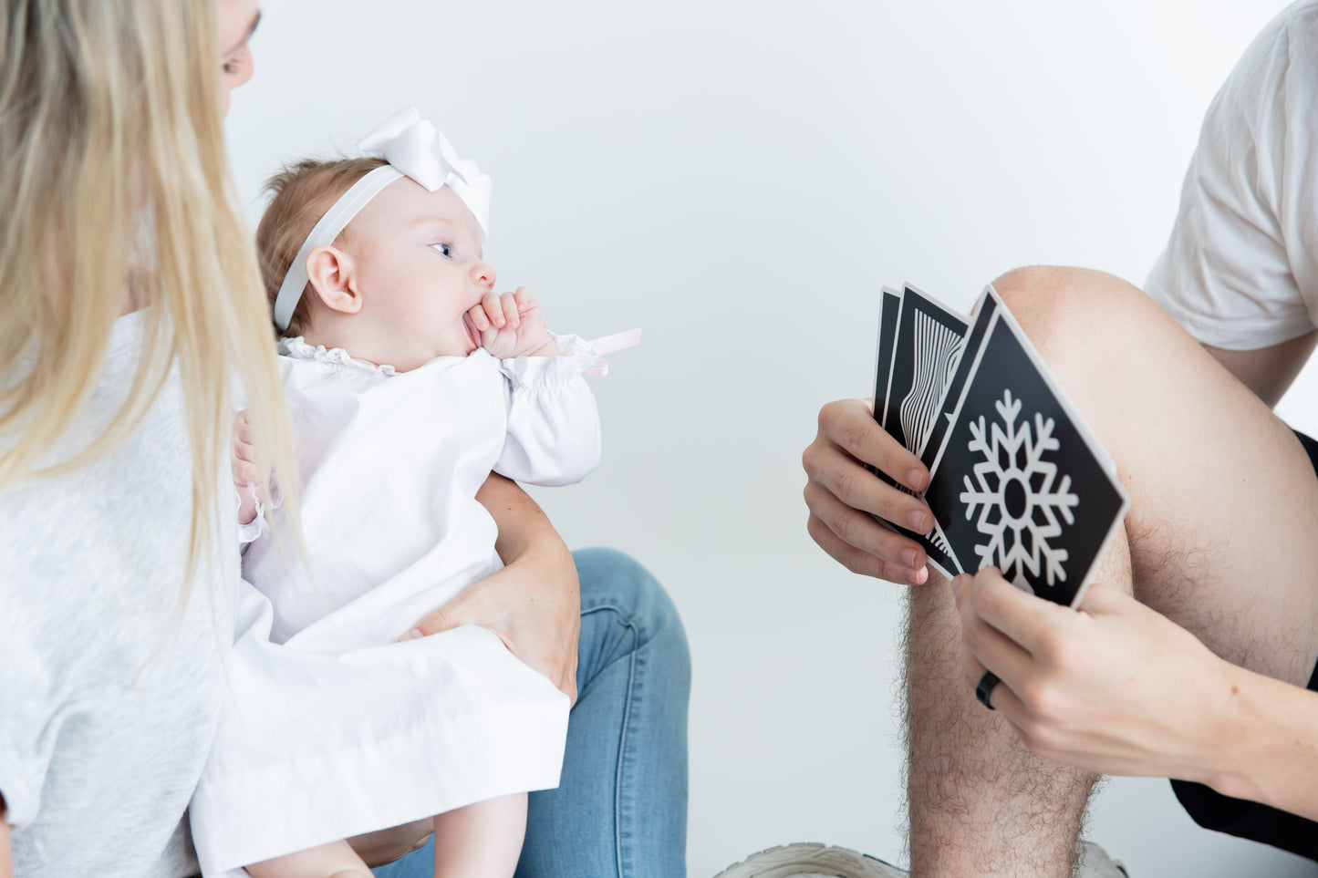 Father showing Baby Geometrics Flashcards Set 1 to his baby, featuring high-contrast black-and-white designs crafted to enhance infant visual stimulation and foster parent-baby bonding moments.