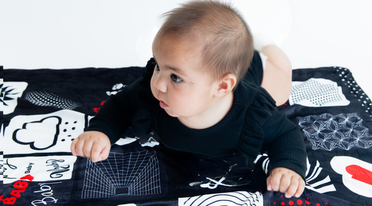 Baby model laying on our custom baby floor mat or baby floor blanket for tummy time.