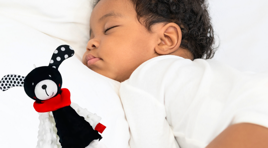 Baby Geometrics Lovey Security Blanket next to a sleeping baby