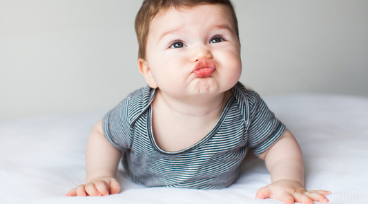 When can babies see color? Picture of baby looking up with funny face. Baby Geometrics products designed for baby vision development. 