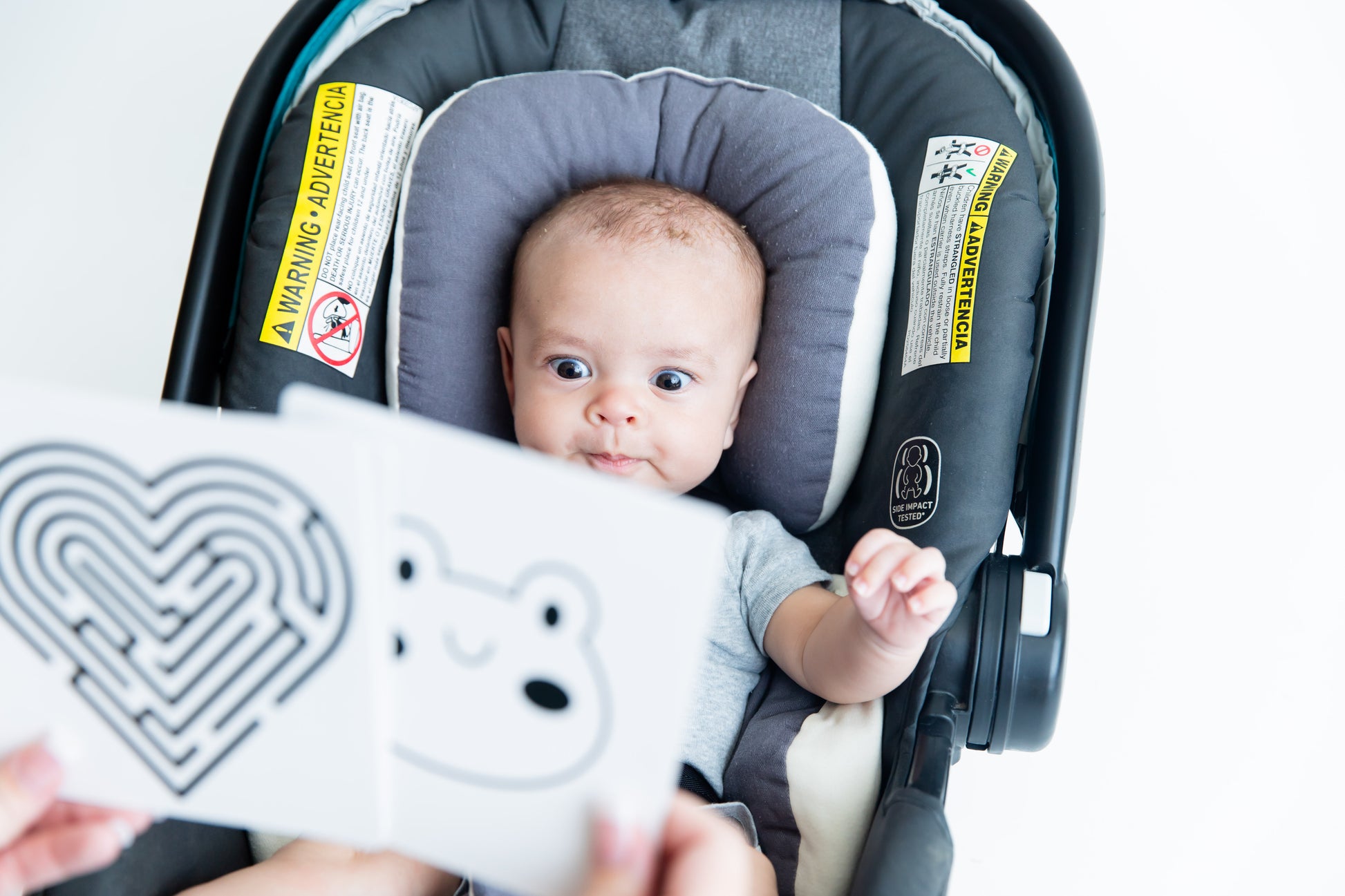 Baby Geometrics Flashcards Set 1, featuring high-contrast black-and-white designs crafted to enhance infant visual stimulation and foster parent-baby bonding moments. Baby is fully engaged with bug curious eyes. 