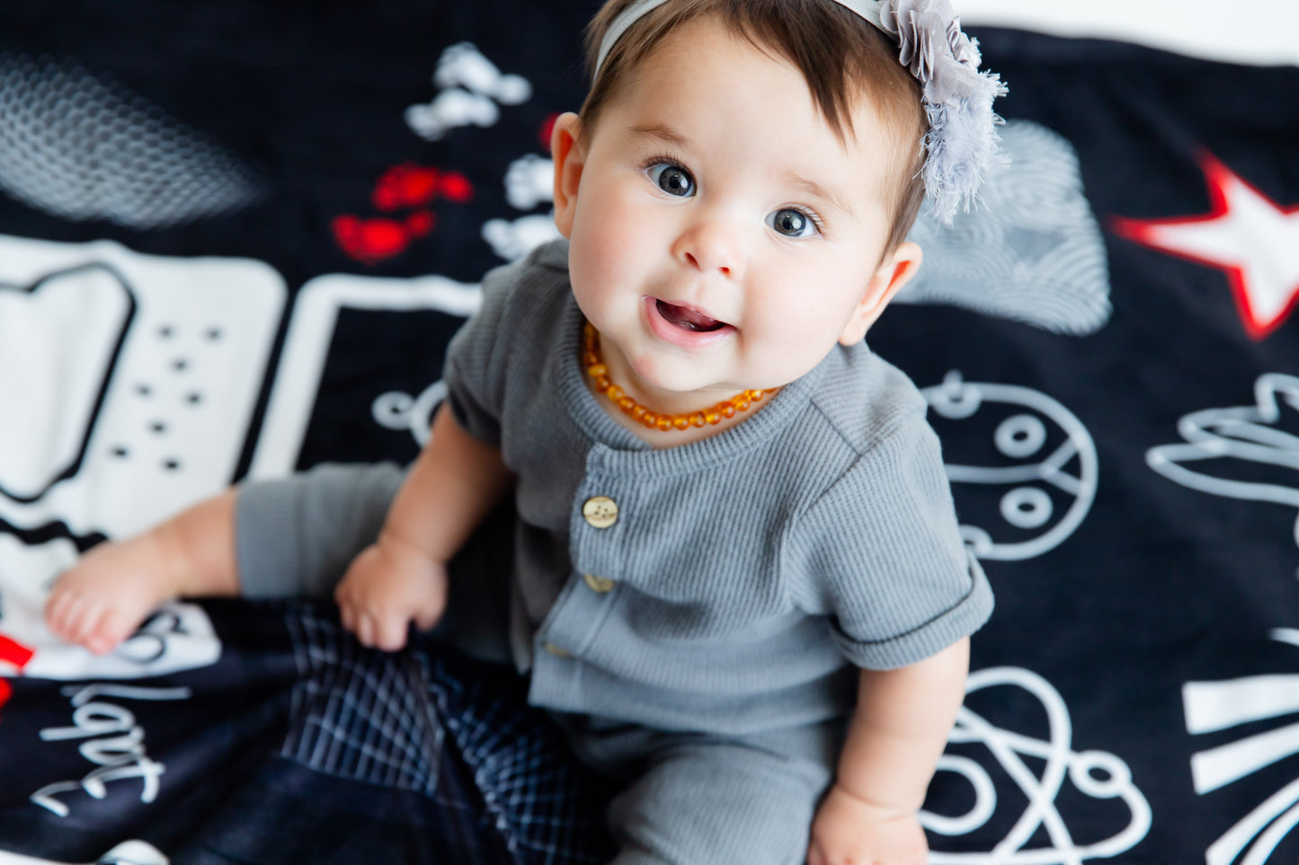 Baby looking up while on the bold black-and-white Baby Geometrics floor blanket, actively engaging their developing vision and focus.
