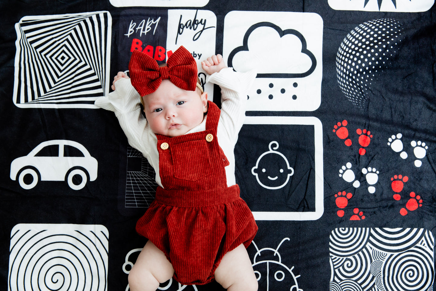 Baby stretching comfortably on the Baby Geometrics floor blanket, enjoying the soft texture and stimulating high-contrast patterns designed for visual and sensory development.