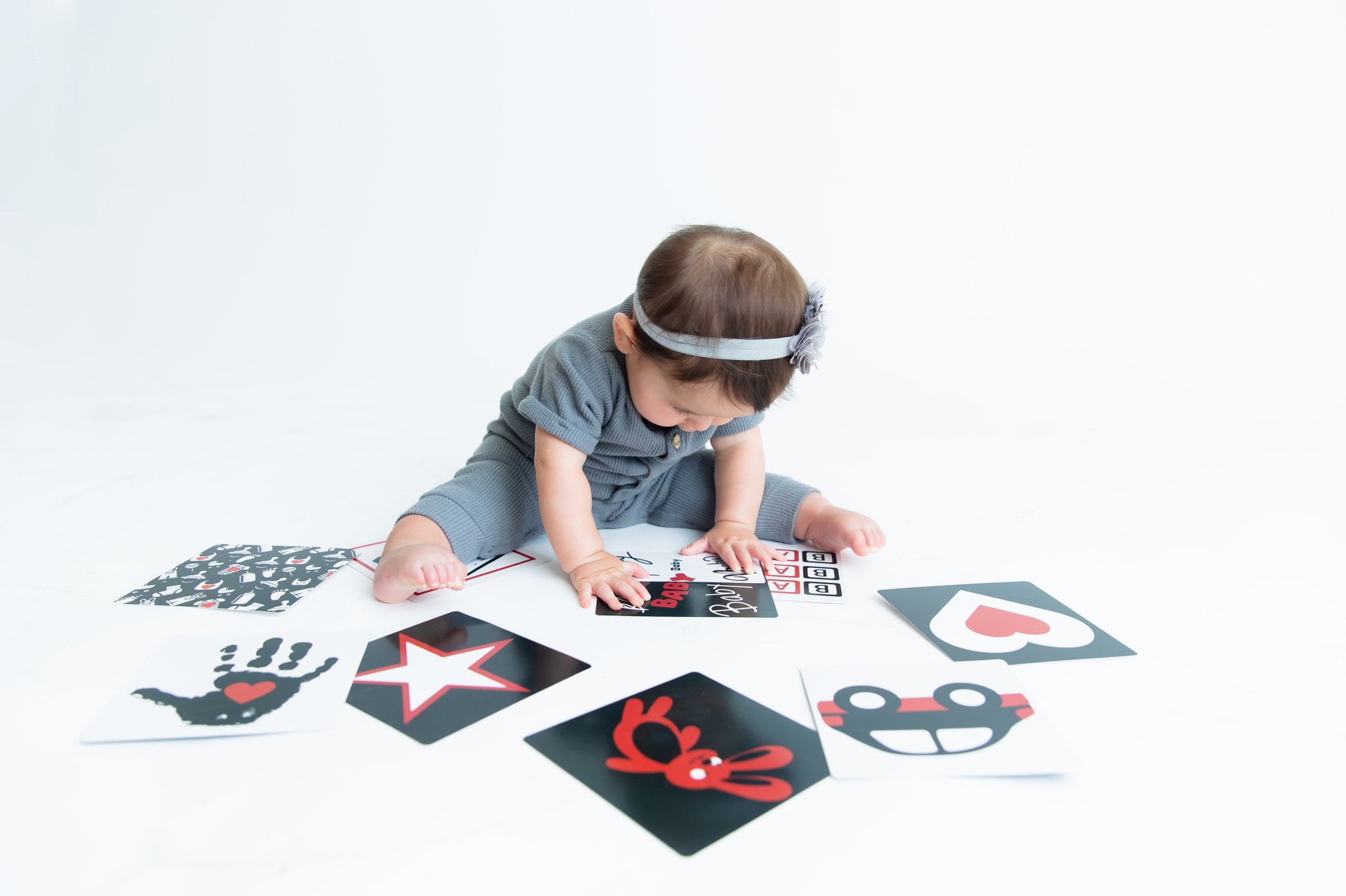 Baby Model is looking down at our high contrast flashcards, designed to encourage focus and brain development.